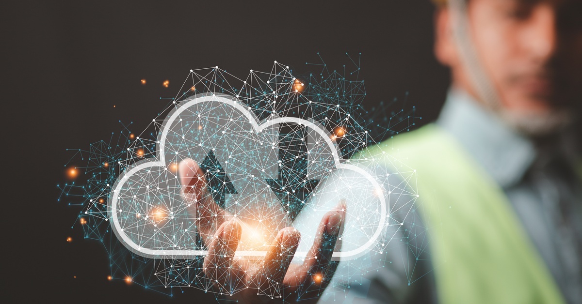 A person in a hard hat holding out their hand and cupping a superimposed graphic of a cloud and numerous data points.