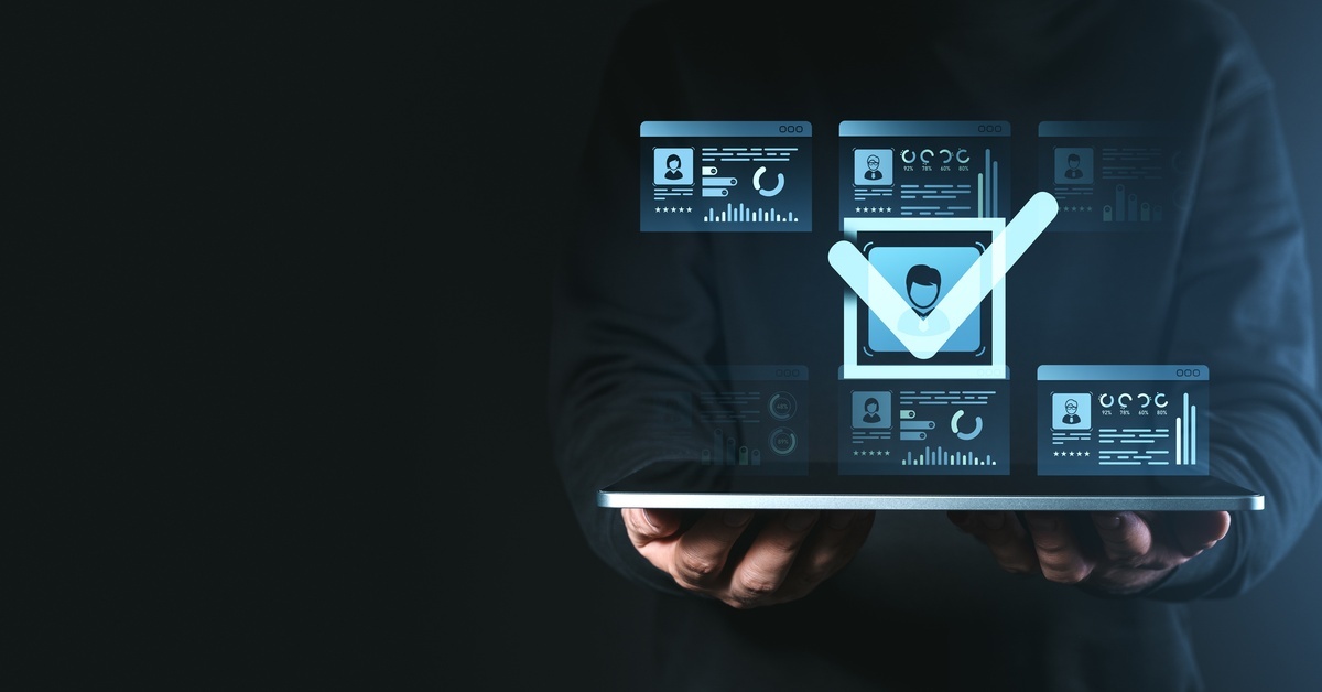 A person holding a tablet. Above the tablet is a series of graphics showing different screens and a large checkmark.